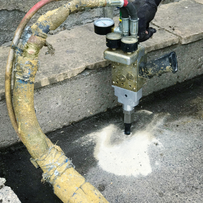 Picture of a machine spraying polyfoam in concrete which is the newest form of mudjacking